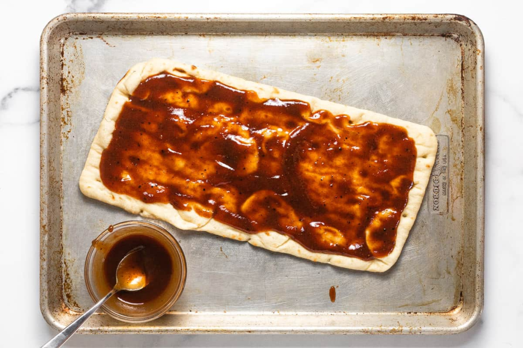 Spread a thin layer of BBQ sauce over the flatbreads.