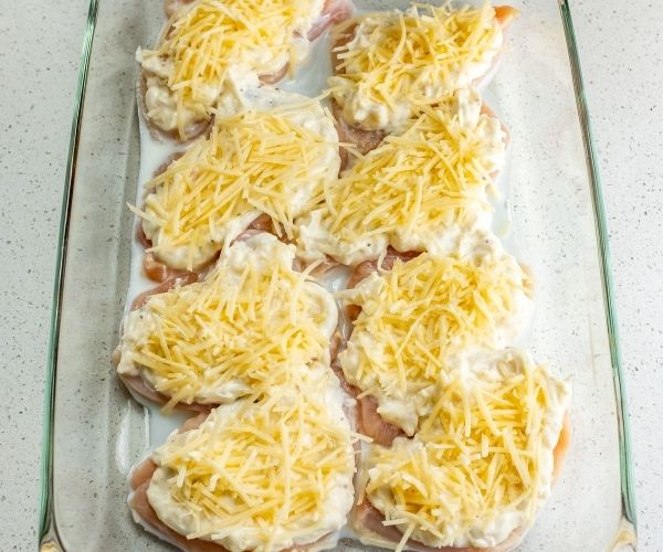 Add the cooked chicken evenly, followed by shredded mozzarella.